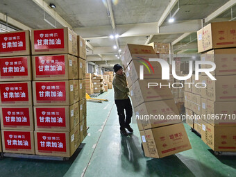 A staff member at a down jacket manufacturer is hauling down jackets to support the quake-hit areas of Jishishan County in Qingzhou, Shandon...