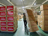 A staff member at a down jacket manufacturer is hauling down jackets to support the quake-hit areas of Jishishan County in Qingzhou, Shandon...