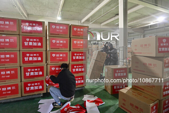 A staff member at a down jacket manufacturer is sorting down jackets to support the quake-hit areas of Jishishan County in Qingzhou, Shandon...