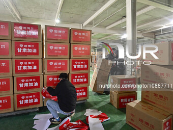 A staff member at a down jacket manufacturer is sorting down jackets to support the quake-hit areas of Jishishan County in Qingzhou, Shandon...