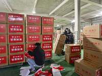 A staff member at a down jacket manufacturer is sorting down jackets to support the quake-hit areas of Jishishan County in Qingzhou, Shandon...