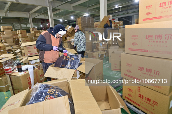 Staff members at a down jacket manufacturer are packaging down jackets to support the quake-hit areas of Jishishan County in Qingzhou, Shand...