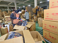 Staff members at a down jacket manufacturer are packaging down jackets to support the quake-hit areas of Jishishan County in Qingzhou, Shand...