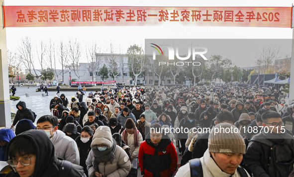 Candidates for the master's degree entrance examination are lining up to enter the test center at Huaiyin Normal University in Huai'an, Chin...