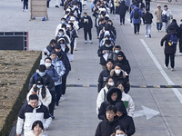 Candidates for the master's degree entrance examination are lining up to enter the test center at Huaiyin Normal University in Huai'an, Chin...