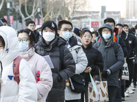 Candidates for the master's degree entrance examination are lining up to enter the test center at Huaiyin Normal University in Huai'an, Chin...