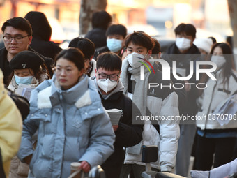 Candidates are preparing to enter the entrance exam for postgraduate students at the No. 15 Middle School exam center in Fuyang, China, on D...