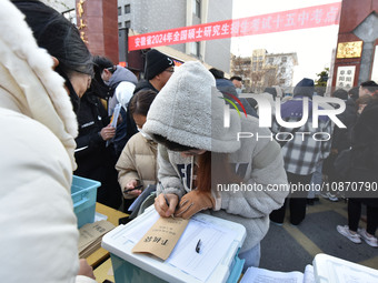 Candidates are preparing to enter the entrance exam for postgraduate students at the No. 15 Middle School exam center in Fuyang, China, on D...