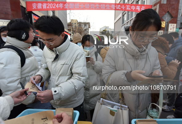 Candidates are preparing to enter the entrance exam for postgraduate students at the No. 15 Middle School exam center in Fuyang, China, on D...