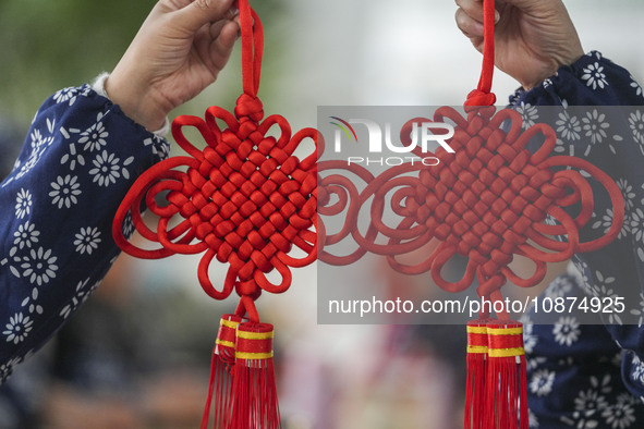 A student is showing a woven Chinese knot at a vocational training school on Dexi Street in Zouping, China, on December 25, 2023. 