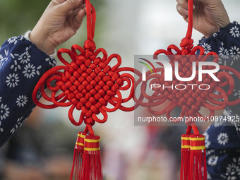 A student is showing a woven Chinese knot at a vocational training school on Dexi Street in Zouping, China, on December 25, 2023. (