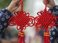 A student is showing a woven Chinese knot at a vocational training school on Dexi Street in Zouping, China, on December 25, 2023. (