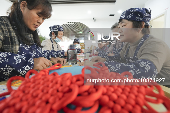 Students are learning to knit Chinese knots at a vocational training school on Dexi Street in Zouping, China, on December 25, 2023. 