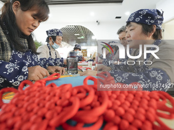 Students are learning to knit Chinese knots at a vocational training school on Dexi Street in Zouping, China, on December 25, 2023. (