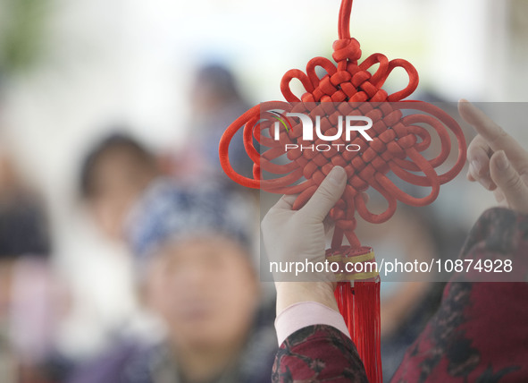 A teacher is teaching students how to knit Chinese knots at a vocational training school on Dexi Street in Zouping, China, on December 25, 2...