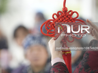 A teacher is teaching students how to knit Chinese knots at a vocational training school on Dexi Street in Zouping, China, on December 25, 2...