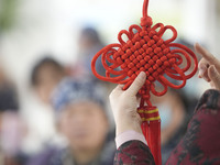 A teacher is teaching students how to knit Chinese knots at a vocational training school on Dexi Street in Zouping, China, on December 25, 2...