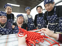 A teacher is teaching students how to knit Chinese knots at a vocational training school on Dexi Street in Zouping, China, on December 25, 2...