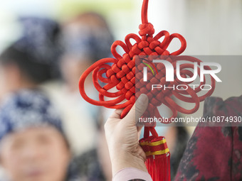 A teacher is teaching students how to knit Chinese knots at a vocational training school on Dexi Street in Zouping, China, on December 25, 2...