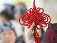 A teacher is teaching students how to knit Chinese knots at a vocational training school on Dexi Street in Zouping, China, on December 25, 2...