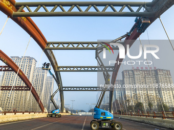 Construction workers are polishing, painting, and maintaining the Zhenxing Bridge in Donghai County, Lianyungang City, Jiangsu Province, Chi...