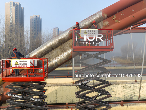 Construction workers are polishing, painting, and maintaining the Zhenxing Bridge in Donghai County, Lianyungang City, Jiangsu Province, Chi...