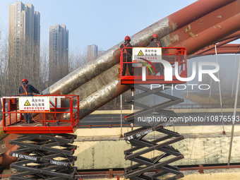 Construction workers are polishing, painting, and maintaining the Zhenxing Bridge in Donghai County, Lianyungang City, Jiangsu Province, Chi...