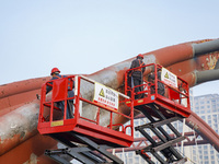 Construction workers are polishing, painting, and maintaining the Zhenxing Bridge in Donghai County, Lianyungang City, Jiangsu Province, Chi...