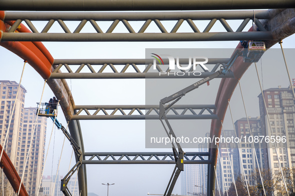 Construction workers are polishing, painting, and maintaining the Zhenxing Bridge in Donghai County, Lianyungang City, Jiangsu Province, Chi...