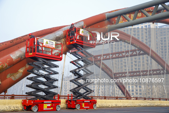 Construction workers are polishing, painting, and maintaining the Zhenxing Bridge in Donghai County, Lianyungang City, Jiangsu Province, Chi...