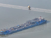 Construction workers are performing an acceptance check on the 200 kV DC transmission line project, which is 100 meters high, in Yangzhou, J...