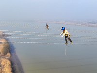 Construction workers are performing an acceptance check on the 200 kV DC transmission line project, which is 100 meters high, in Yangzhou, J...