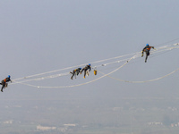 Construction workers are performing an acceptance check on the 200 kV DC transmission line project, which is 100 meters high, in Yangzhou, J...