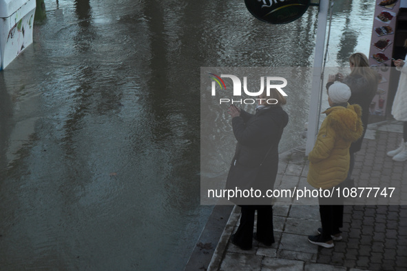 Passersby are looking at the flooding Danube as a wave of floods is expected on the river, in Budapest, Hungary, on December 28, 2023.  