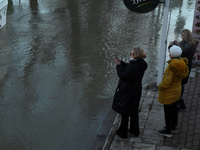 Passersby are looking at the flooding Danube as a wave of floods is expected on the river, in Budapest, Hungary, on December 28, 2023.  (