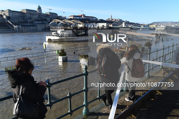 People are looking at the embankment of the Danube as a wave of floods is expected on the river, in Budapest, Hungary, on December 28, 2023....