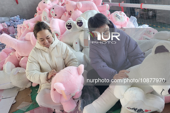 Workers are processing plush toys for export at a toy factory in Lianyungang City, East China's Jiangsu Province, on December 28, 2023. 