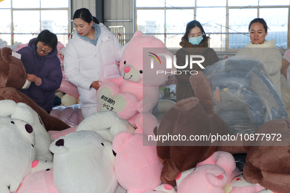 Workers are processing plush toys for export at a toy factory in Lianyungang City, East China's Jiangsu Province, on December 28, 2023. 