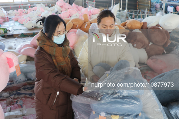 Workers are processing plush toys for export at a toy factory in Lianyungang City, East China's Jiangsu Province, on December 28, 2023. 