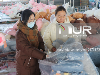 Workers are processing plush toys for export at a toy factory in Lianyungang City, East China's Jiangsu Province, on December 28, 2023. (