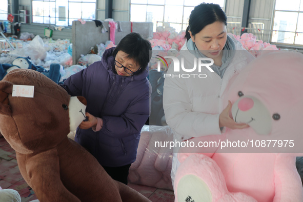 Workers are processing plush toys for export at a toy factory in Lianyungang City, East China's Jiangsu Province, on December 28, 2023. 