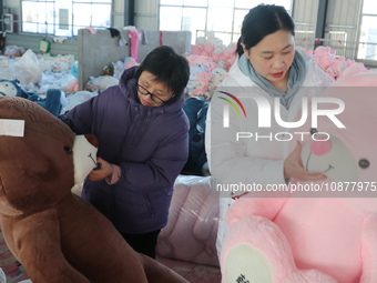 Workers are processing plush toys for export at a toy factory in Lianyungang City, East China's Jiangsu Province, on December 28, 2023. (