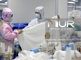 Qiu Zhanglei, a master's student, is checking the quality of medical products being produced in a workshop of a private medical device manuf...