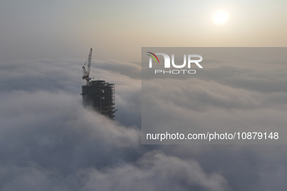 Workers are working on the 416.6-meter-high Hexi City II roof in heavy fog in Nanjing, Jiangsu Province, China, on December 29, 2023. 