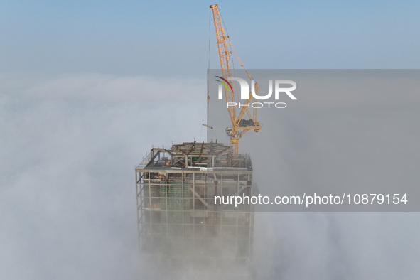 Workers are working on the 416.6-meter-high Hexi City II roof in heavy fog in Nanjing, Jiangsu Province, China, on December 29, 2023. 