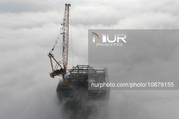 Workers are working on the 416.6-meter-high Hexi City II roof in heavy fog in Nanjing, Jiangsu Province, China, on December 29, 2023. 