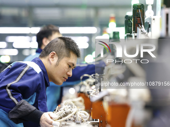 A worker is working on the production line of an electronic components company in Suqian, Jiangsu Province, China, on December 29, 2023. (