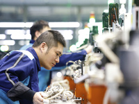 A worker is working on the production line of an electronic components company in Suqian, Jiangsu Province, China, on December 29, 2023. (