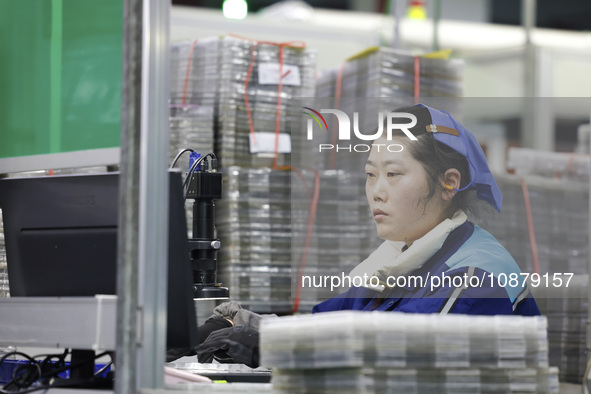 A worker is working on the production line of an electronic components company in Suqian, Jiangsu Province, China, on December 29, 2023. 