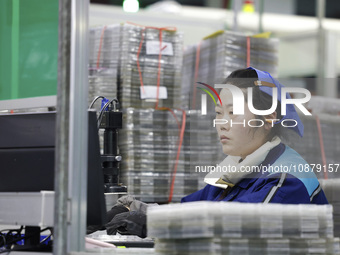 A worker is working on the production line of an electronic components company in Suqian, Jiangsu Province, China, on December 29, 2023. (